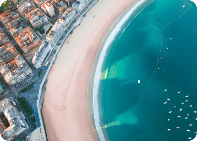 Vista aérea de la playa con arena dorada y aguas azules