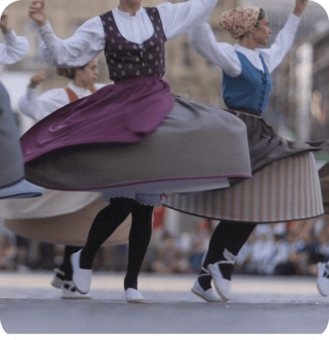 Bailarinas con vestimenta tradicional interpretando una danza folclórica vasca.