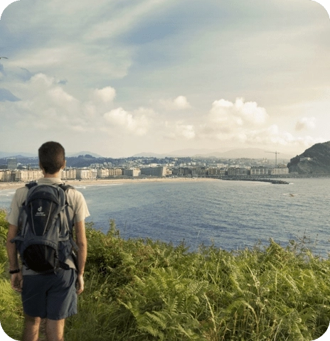 Joven observando la playa de La Concha desde lo alto del monte.