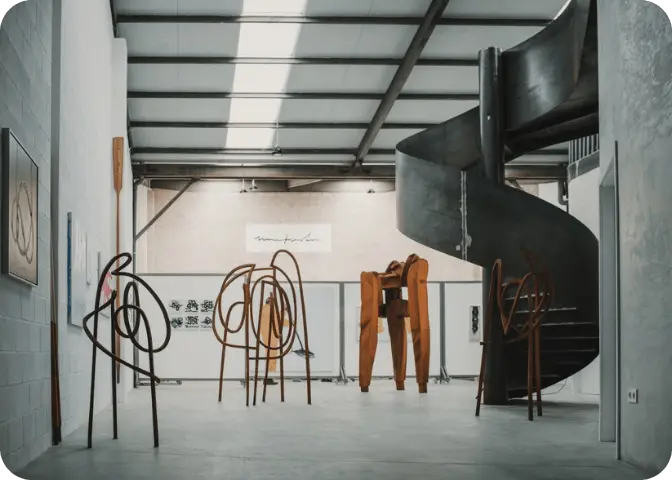 Galería de arte con esculturas y pinturas expuestas.